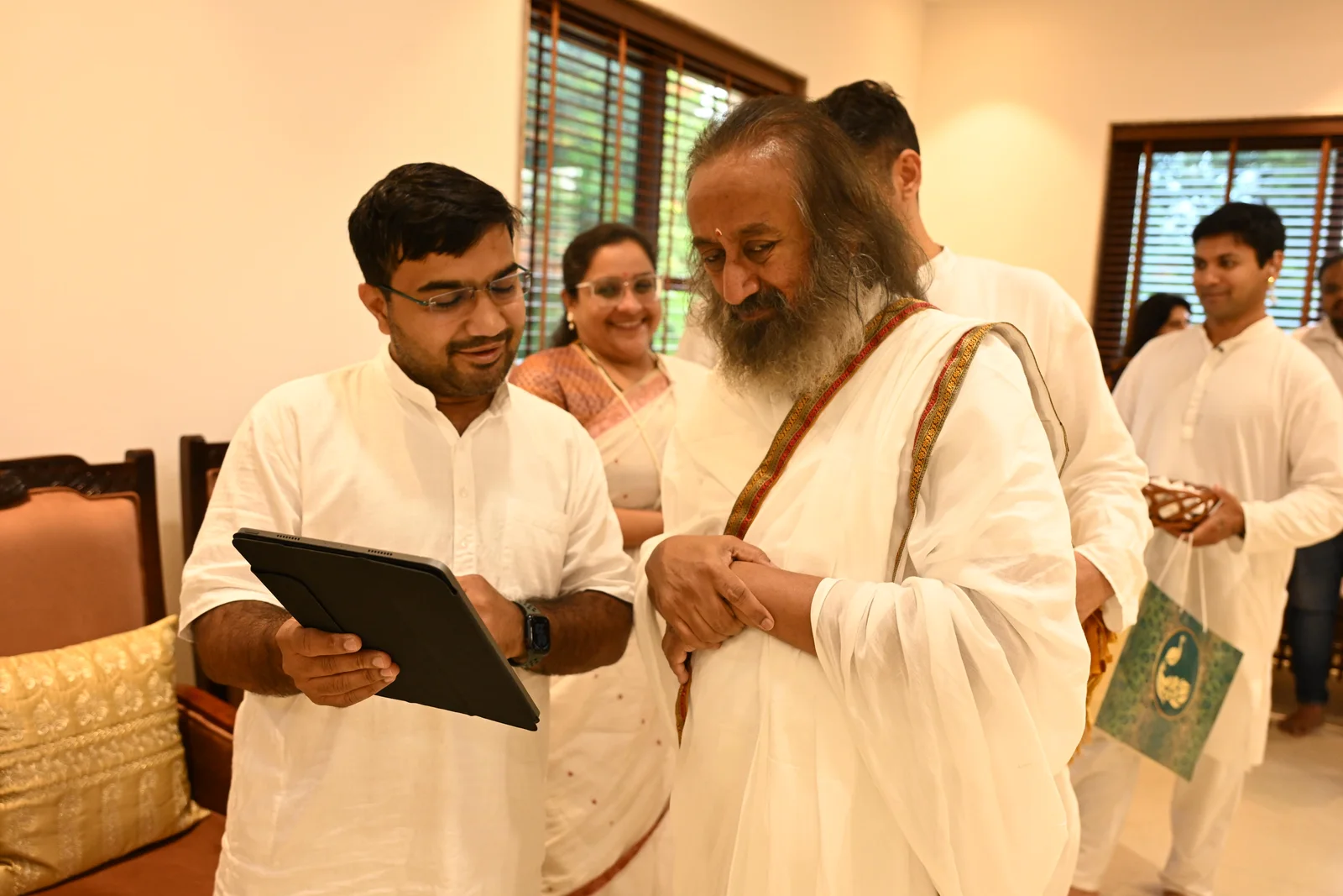 Nimesh Pancholi showing the first Zenith Wealth website on a tablet to Gurudev Sri Sri Ravi Shankar, Bengaluru, May 2025